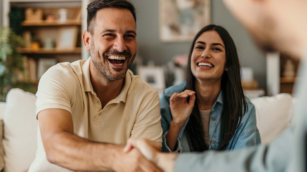 Two new homeowners signing their contract on their home.