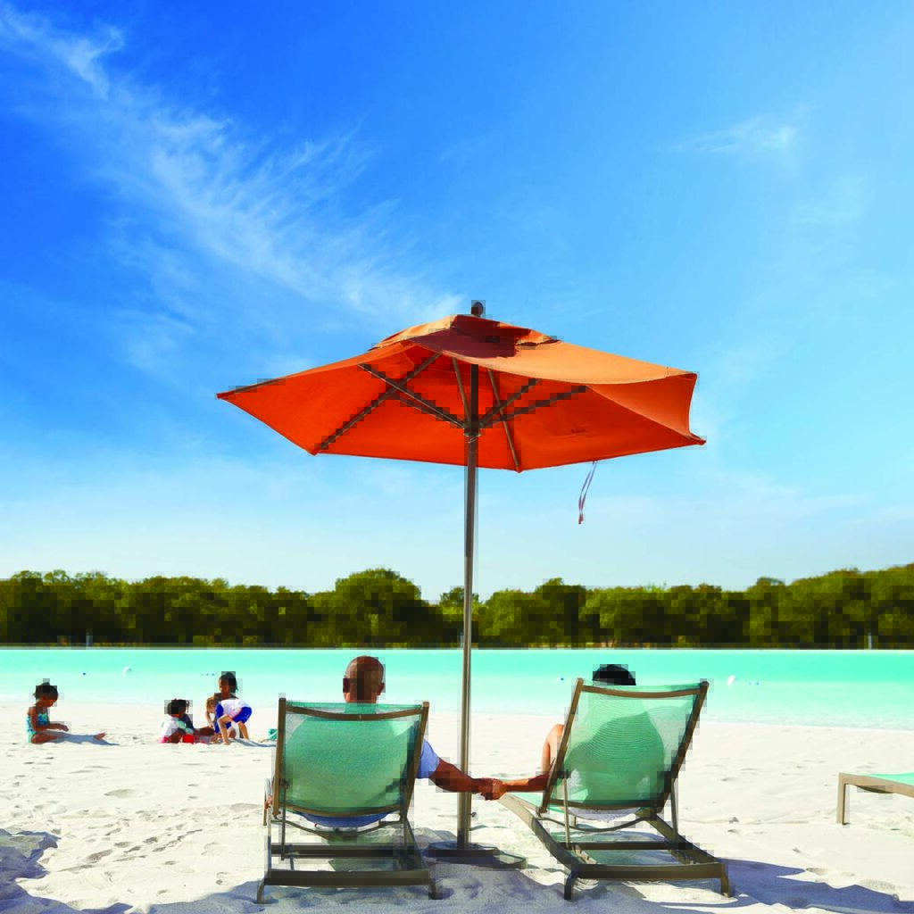Two people lounging at The Lagoon at the Windsong Ranch community in Prosper, TX.